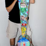 Image of Charles Fazzino standing next to the New Rochelle town installation he created