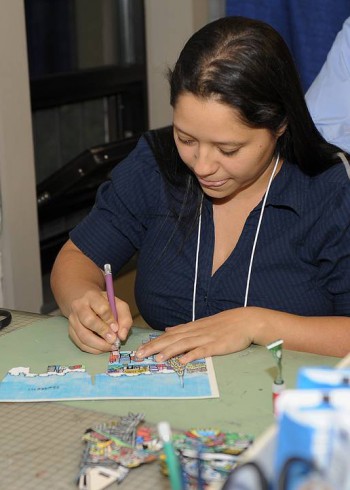 Image of a women named Jessica showing the workshop attendees how to cut for their 3D paintings