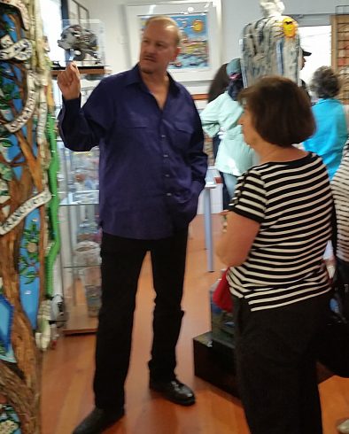 Charles Fazzino in his studio at Arts Fest describing his artwork to a fan