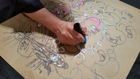 Charles Fazzino hand doodling a piece for a client on cardboard