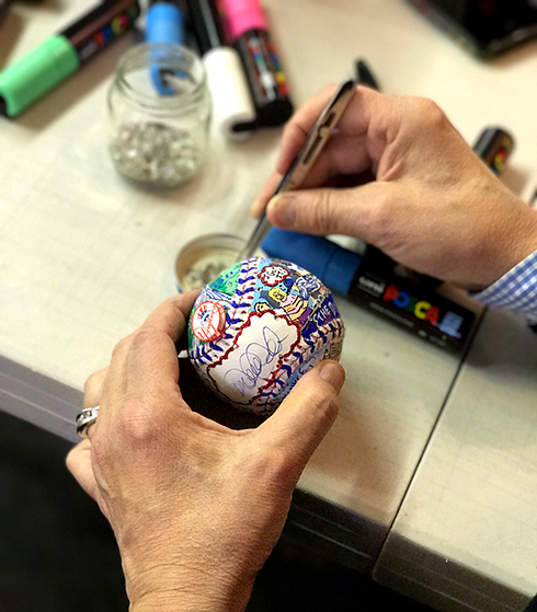 Charles Fazzino adds crystals to decorate the baseball