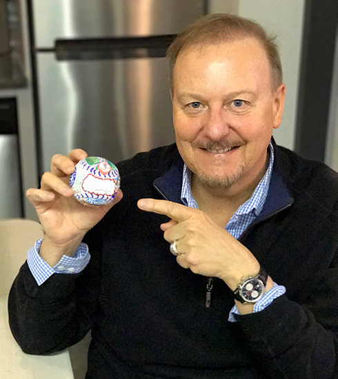 Charles Fazzino holds a baseball art creation that is in progress