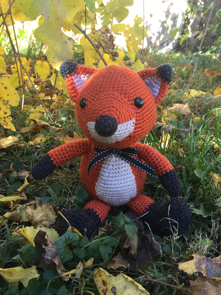 Orange and white fox sitting in the grass during autumn | Christina's Crocheted Characters