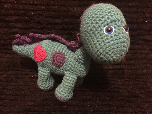 A green and maroon crocheted dinosaur with a red heart | Christina's Crocheted Characters