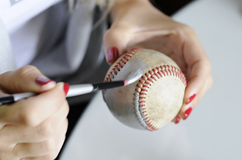 Painting a baseball with silver paint and a brush