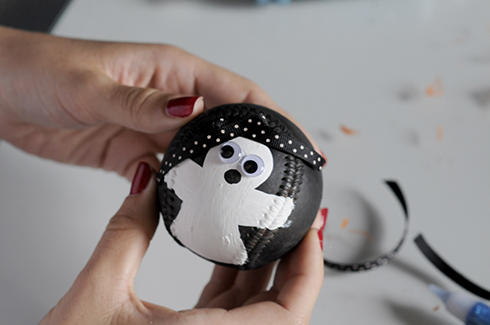 A black with white polka dot ribbon added as a bow to a ghost baseball art