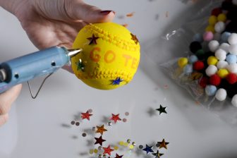 Adhering stars in different colors to a baseball to create an art piece