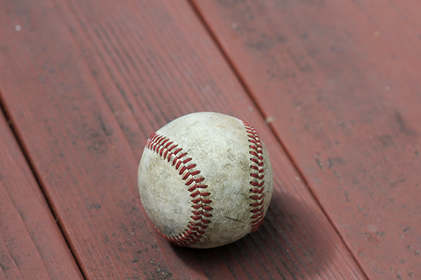 A baseball sits in the sun on a picnic table to dry out in preparation for creating artwork with it