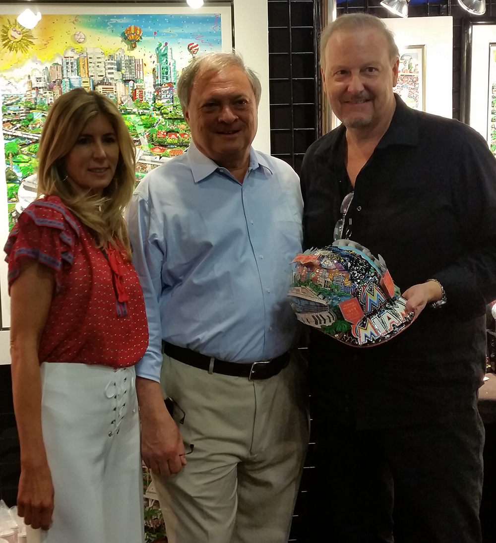 Charles Fazzino holding MLB All-Star 3D baseball helmet standing next to Marlins Owners Jeffrey and Julie Loria