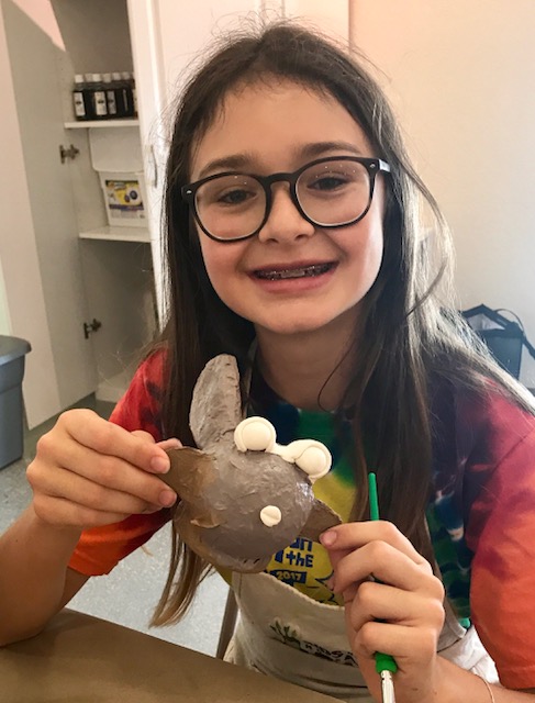 Brown haired girl holding up her pufferfish creation from Charles Fazzinos All-Star Ball Star contest