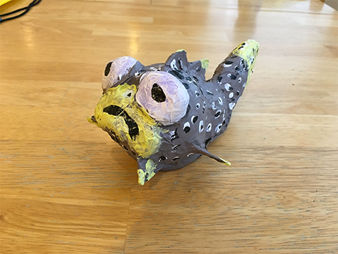 A baseball covered with paper to create a grey and yellow lipped puffer fish