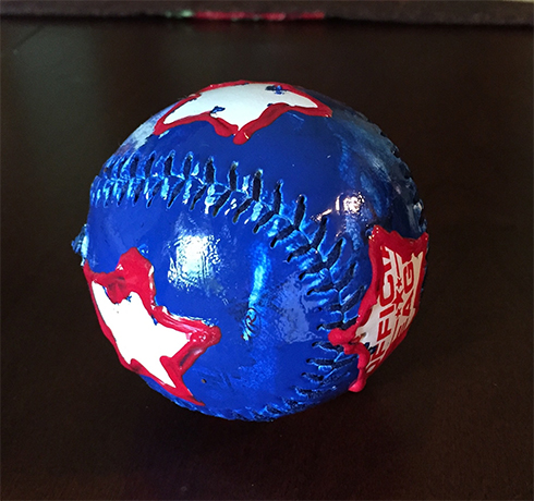 A baseball painted blue with white stars lined in red to look patriotic