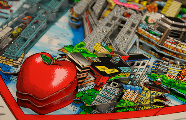 A close up of a Fazzino artwork showing an apple in 3D