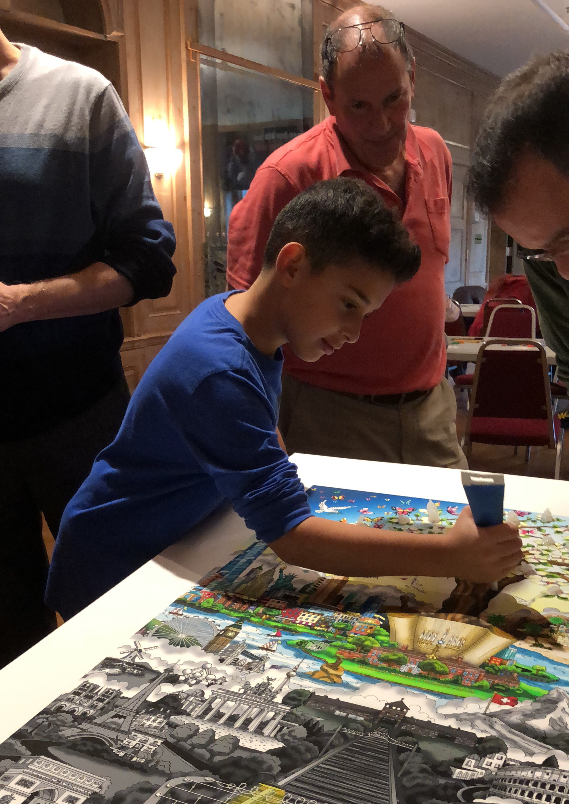 Young boy in a blue shirt adding glue dots to create 3d pop art 