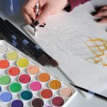 Using white crayon around the outside of a pineapple painting to isolate layers