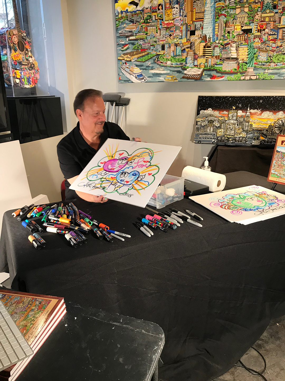 Charles Fazzino showing off a pop art doodle during his skype interview in his gallery in New Rochelle