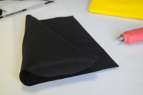 Folding black felt into a triangular shape for the body of the bee