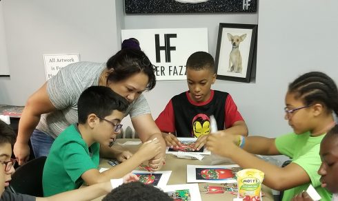 Sonia Marshall-Brown from "It Takes a Village to Educate a Child" program helping her students with a Charles Fazzino art project