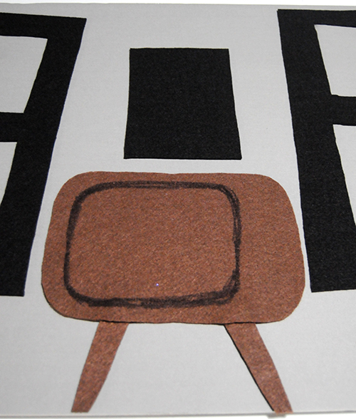 A vintage television cut out of brown felt on a grey paper board