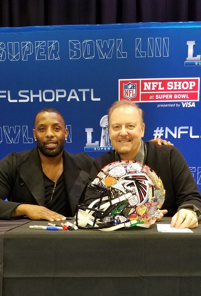 Charles Fazzino and Atlanta Falcons player William Moore sign posters for fans at the NFL Experience during Super Bowl LIII