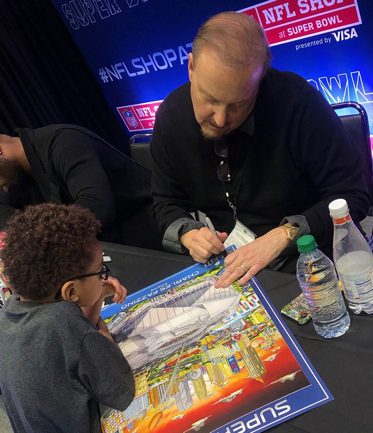 Charles Fazzino signing a Super Bowl LIII poster for a young football fan at the NFL Shop in Atlanta