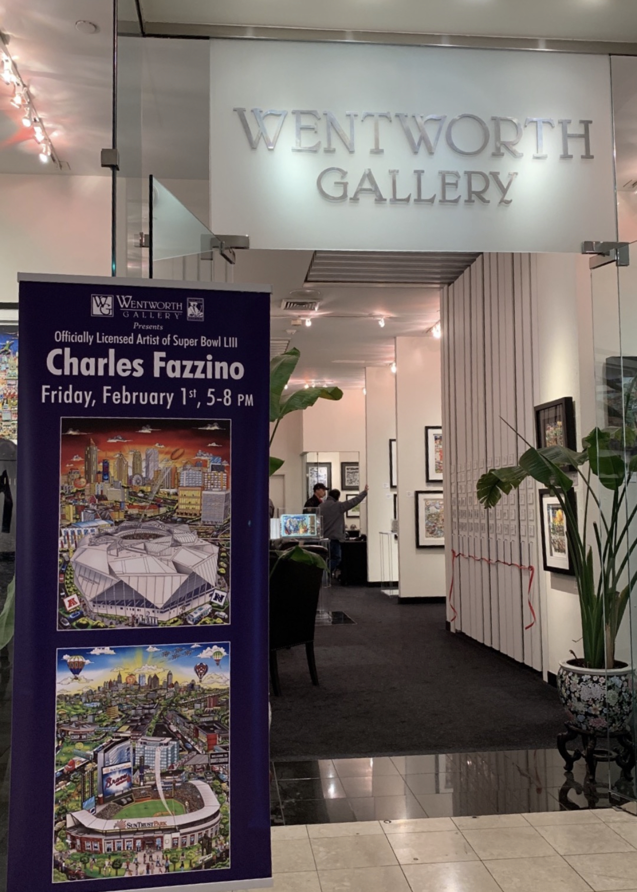 A view from outside the Wentworth Gallery looking in at artwork by Charles Fazzino