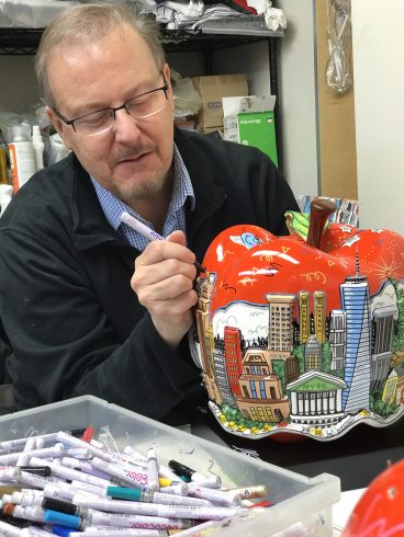 A photo of Charles Fazzino working on one of his famous apples.