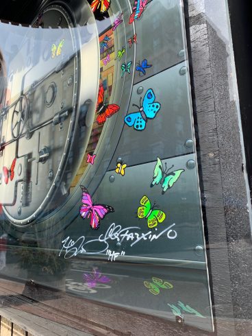 Up close image of a kiosk covered in painted butterflies.