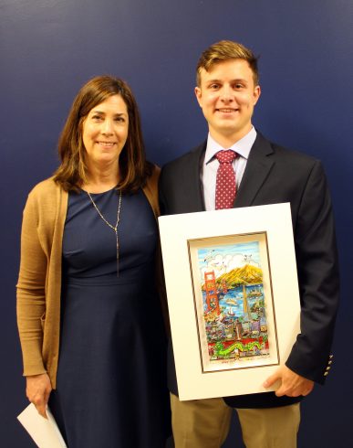 A young man, Andrew Clausen (right) is holding the Charles Fazzino Award of the Heart from Project Community Board Member Anne O'Beirne (left).