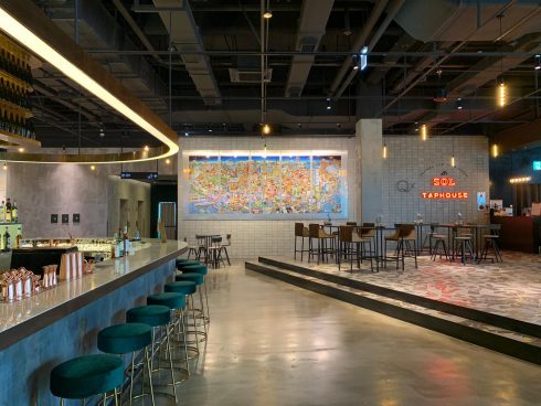 Food court with a large mural by Charles Fazzino on the wall.