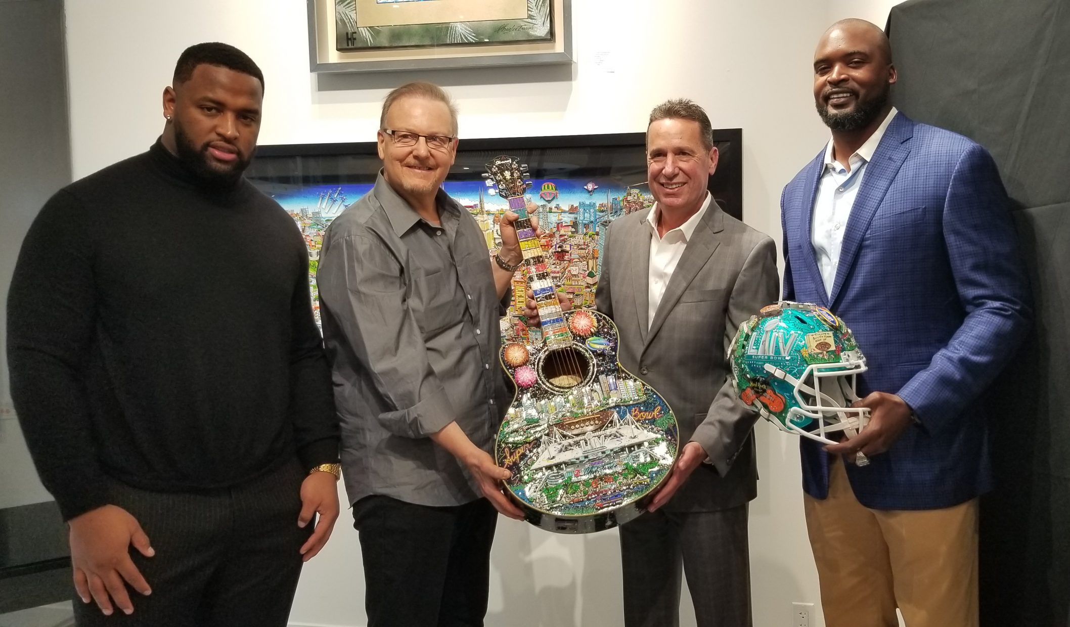 Posing with a Fazzino Super Bowl LIV guitar and helmet, from left to right: Miami Dolphin Davon Godchaux, President of the Hard Rock Hotel & Casino Bo Guidry, Former NY Giant Mathias Kiwanuka, and Charles Fazzino