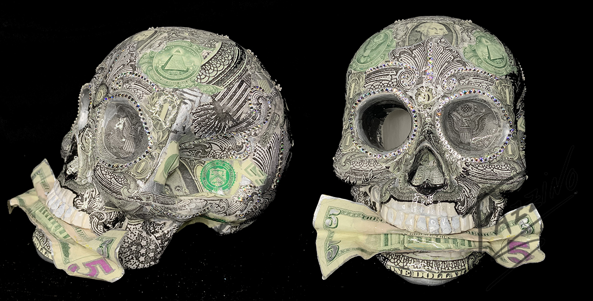 Sculpture in the shape of a skull, adorned with Swarovski crystals and a $5 bill in it's mouth