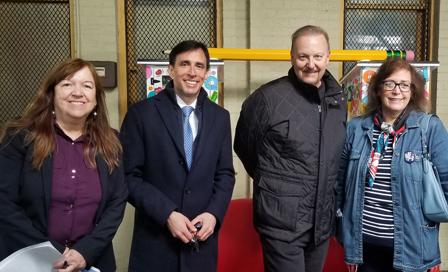 Charles Fazzino and city officials smiling in front of his latest pop art installation down at the New Rochelle train station