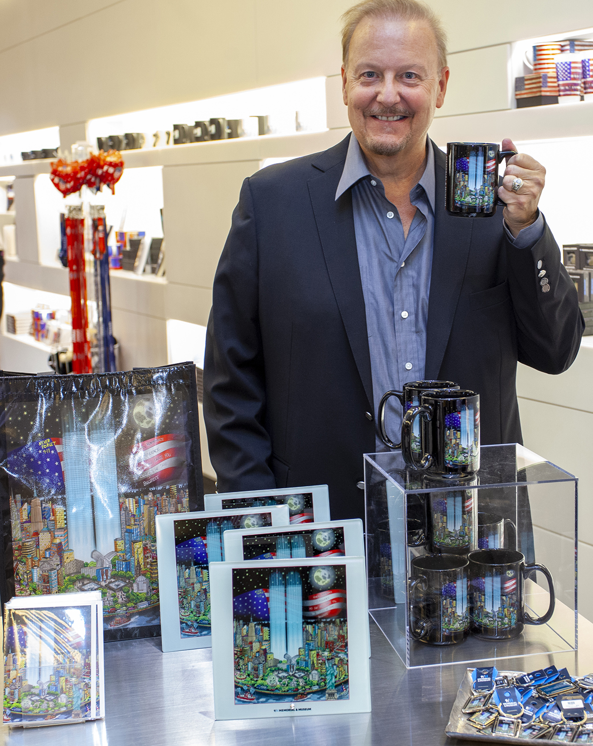 Charles Fazzino holding his pop art 9/11 commemorative mug at the 9/11 Memorial & Museum. 