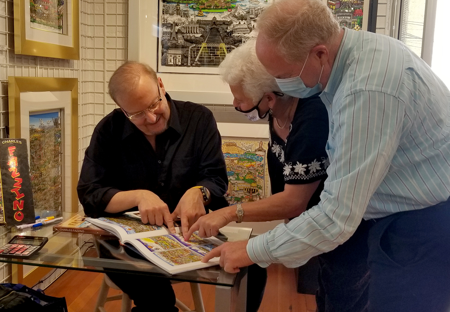 Fazzino with some collectors admiring one of his art books