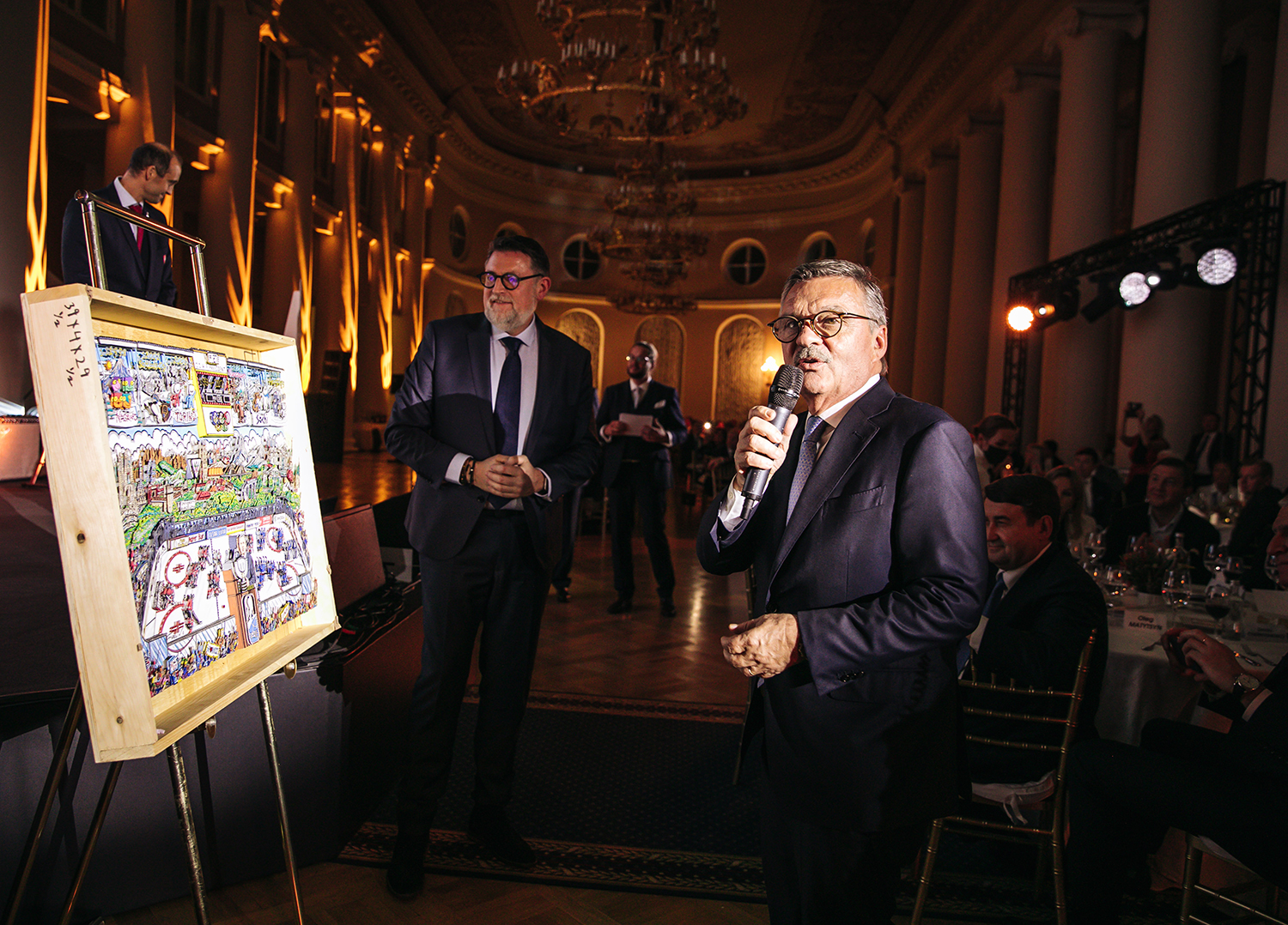 Dr. Rene Fasel holding a microphone, talking