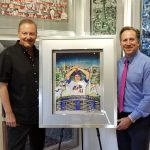 Charles Fazzino and Bruce Beck stand on either side of a Mets baseball art piece, smiling at the camera