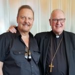 Charles Fazzino and Cardinal Dolan stand side by side with arms around each other