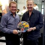 Charles Fazzino and Joe Theismann hold an artistically decorated NFL helmet