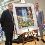 Charles Fazzino and Pete Alonso stand on either side of a large art piece, depicting the twin towers surrounded by smaller skyscraper buildings