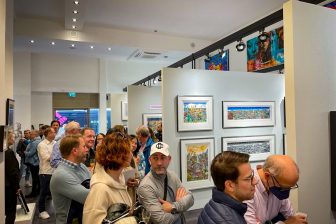 A crowd of people gathered at an art gallery in Mensing, Germany