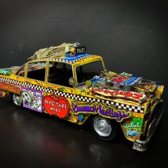 Side view of a car sculpture covered in Broadway elements.