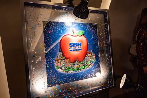 Fazzino's artwork for the Team of Heroes gala features a large apple in the center of a New York City landscape